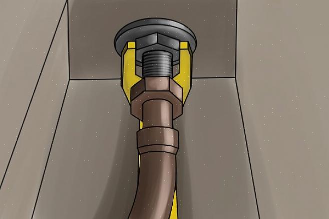 (På bildet her er hodet plassert for å løsne mutteren.) Bruk T-stangen på enden av vaskenøkkelen til å vri