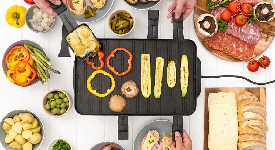 Grillen varmer opp flere små panner der gjestene smelter raclette med grønnsaker